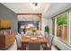 Sunlit dining room with open view to the kitchen and a large window providing natural light at 1765 S Kline Way, Lakewood, CO 80232