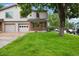 Traditional home featuring a well-manicured lawn and an attached two-car garage in a tranquil neighborhood at 1765 S Kline Way, Lakewood, CO 80232