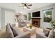 Bright living room featuring a cozy brick fireplace, ceiling fan and neutral colored furniture at 1765 S Kline Way, Lakewood, CO 80232