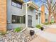 Charming townhome with stone landscaping, brick chimney, gray siding and well-maintained facade at 8777 W Cornell Ave # 2, Lakewood, CO 80227