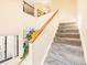 Carpeted staircase with wooden railing ascending into a naturally lit and neutral-toned interior at 8777 W Cornell Ave # 2, Lakewood, CO 80227