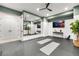 Basement gym with large mirror, yoga mats and a TV at 6561 S Harlan Ct, Littleton, CO 80123