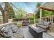 Back deck featuring comfortable wicker seating and a firepit perfect for outdoor entertaining at 11245 San Joaquin Rdg, Littleton, CO 80127