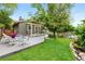 Spacious backyard with a lush lawn, concrete patio, and comfortable white wicker outdoor seating at 11245 San Joaquin Rdg, Littleton, CO 80127