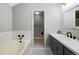 Bright bathroom featuring a soaking tub, blue vanity, and tiled floors at 11245 San Joaquin Rdg, Littleton, CO 80127