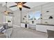 Spacious living room featuring built-in bookshelves, soft carpeting, and an overhead fan at 11245 San Joaquin Rdg, Littleton, CO 80127