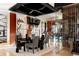 Modern dining room features unique striped chairs, a glass-encased wine cellar, and stylish decor at 24360 E Glasgow Dr, Aurora, CO 80016