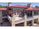 Aerial view of a grand home boasting a red metal roof and multiple outdoor decks at 24360 E Glasgow Dr, Aurora, CO 80016