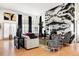 Elegant living room with marble accent wall, zebra print chairs, hardwood floors, and black accents at 24360 E Glasgow Dr, Aurora, CO 80016