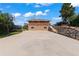 Spacious backyard featuring a large paved area, stone retaining wall, and outdoor recreational facilities at 1380 Oak Valley Rd, Sedalia, CO 80135