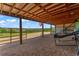 Covered outdoor area providing a shaded retreat with views of the surrounding greenery and distant landscape at 1380 Oak Valley Rd, Sedalia, CO 80135