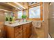 Bathroom featuring a granite vanity, beautiful wooden cabinets, and a large, well-lit mirror at 1380 Oak Valley Rd, Sedalia, CO 80135