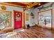 Warm entryway with wood floors, a red front door, and charming decor creating a welcoming atmosphere at 1380 Oak Valley Rd, Sedalia, CO 80135