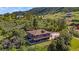 Stunning aerial view of a multi-level home with wraparound deck nestled in a lush, green landscape at 1380 Oak Valley Rd, Sedalia, CO 80135