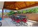 Charming outdoor dining area featuring a covered patio, dining set, and lovely garden surroundings at 1380 Oak Valley Rd, Sedalia, CO 80135