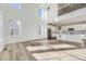 Open-concept kitchen with stainless steel appliances, white cabinetry, and hardwood flooring at 39886 Floyd St, Elizabeth, CO 80107