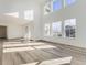 Bright living room featuring soaring ceilings, large windows, and beautiful hardwood floors at 39886 Floyd St, Elizabeth, CO 80107