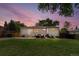 Charming backyard featuring green grass, a patio area with furniture, a grill, and privacy fencing under a dusk sky at 9220 Yucca Way, Thornton, CO 80229