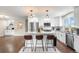 Bright kitchen with center island, stainless appliances, white cabinetry, and hardwood floors at 9220 Yucca Way, Thornton, CO 80229