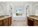 Bright primary bathroom featuring dual vanities, soaking tub, and modern fixtures at 7837 Aravon Ct, Lone Tree, CO 80124
