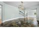 Elegant dining room showcases slate floors, a modern chandelier, and seamless transitions to adjacent living areas at 7837 Aravon Ct, Lone Tree, CO 80124