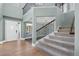 Grand entryway with soaring ceilings, hardwood floors, carpeted stairs, and iron railings showcases a modern design at 7837 Aravon Ct, Lone Tree, CO 80124