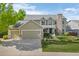 Inviting two-story home boasts a manicured lawn, three-car garage, and charming stone accents, perfect for suburban living at 7837 Aravon Ct, Lone Tree, CO 80124