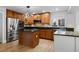 A kitchen with wood cabinets, stainless steel appliances and a black countertop island at 7837 Aravon Ct, Lone Tree, CO 80124