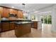 An open concept kitchen with wood cabinets, island, stainless steel appliances and light wood flooring at 7837 Aravon Ct, Lone Tree, CO 80124