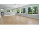 Open living room with hardwood floors, large windows providing ample light, and seamless flow to adjacent rooms at 7837 Aravon Ct, Lone Tree, CO 80124