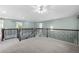 Second-floor loft area with carpet flooring, wrought iron railing, and neutral paint at 7837 Aravon Ct, Lone Tree, CO 80124