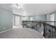 Large loft with neutral carpet and paint, wrought iron railing, and bright lighting at 7837 Aravon Ct, Lone Tree, CO 80124