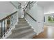 Elegant staircase featuring carpeted steps, decorative iron railings, and wood accents, connects multiple levels of the home at 7837 Aravon Ct, Lone Tree, CO 80124