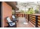 Inviting back porch with wood decking, comfortable seating, and an umbrella for shade; brick exterior at 121 S Ivy St, Denver, CO 80224