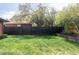 Lush green backyard with privacy fence, mature trees, and space for outdoor activities at 121 S Ivy St, Denver, CO 80224