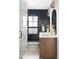Modern bathroom featuring double vanity, black tiled wall, and glass enclosed shower at 121 S Ivy St, Denver, CO 80224