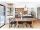 Bright open-concept dining area with a modern wood table, black chairs, and an island with pendant lighting at 121 S Ivy St, Denver, CO 80224