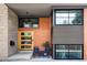 Modern exterior with brick facade, a wood front door, and stylish outdoor seating creates an inviting entrance at 121 S Ivy St, Denver, CO 80224
