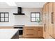Bright, updated kitchen with stainless steel appliances, a black range hood, and wood cabinets for plenty of storage at 121 S Ivy St, Denver, CO 80224