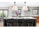 Bright kitchen features modern light fixtures, a white countertop island with black chairs, and stainless steel appliances at 121 S Ivy St, Denver, CO 80224