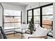 Modern living room features black-framed windows, white armchairs, and wood floors at 121 S Ivy St, Denver, CO 80224