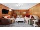 Cozy living room featuring wood paneling, carpet floors, and comfortable seating at 121 S Ivy St, Denver, CO 80224