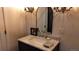 Stylish bathroom featuring a vanity with marble countertop, arched mirror, and chandelier-style sconces at 640 N Magnolia St, Denver, CO 80220