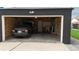 Interior of a garage with exposed insulation, a black car parked inside, and a white door at 640 N Magnolia St, Denver, CO 80220