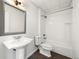 Bathroom with a pedestal sink, toilet and white tiled shower and tub at 3712 Wolff St, Denver, CO 80212