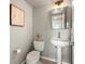 Powder room featuring a pedestal sink, modern toilet, and gray walls at 3712 Wolff St, Denver, CO 80212