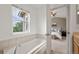Bathroom featuring soaking tub with a view and a doorway to the bedroom at 3712 Wolff St, Denver, CO 80212