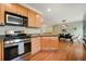 Open kitchen featuring wooden cabinets, stainless appliances, granite countertops, and hardwood floors at 3712 Wolff St, Denver, CO 80212