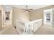 Hallway with ceiling fan and white wood railing leads to various rooms in the home at 3706 E Easter Dr, Centennial, CO 80122