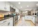 Bright kitchen with white cabinets, stainless steel appliances, and an adjacent dining area offers ample space for cooking and entertaining at 3706 E Easter Dr, Centennial, CO 80122